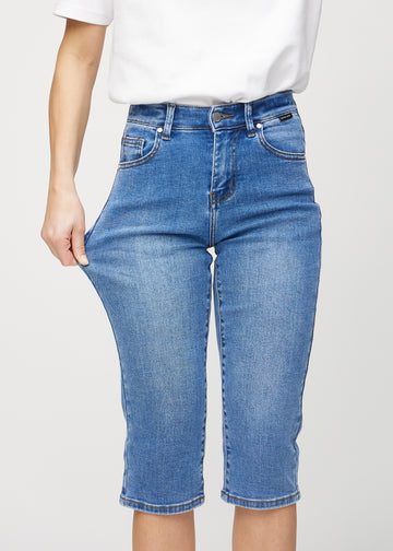 Model strækker caprisene ved låret for at vise stretch.