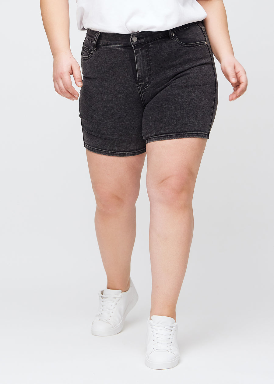 Mørkegrå denim skinny short shorts, modelnavn Shadows, som sidder tæt til, og slutter midt på låret på en plus-size model, set forfra.