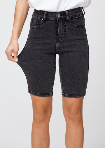 Model strækker shortsene ved låret for at vise stretch.