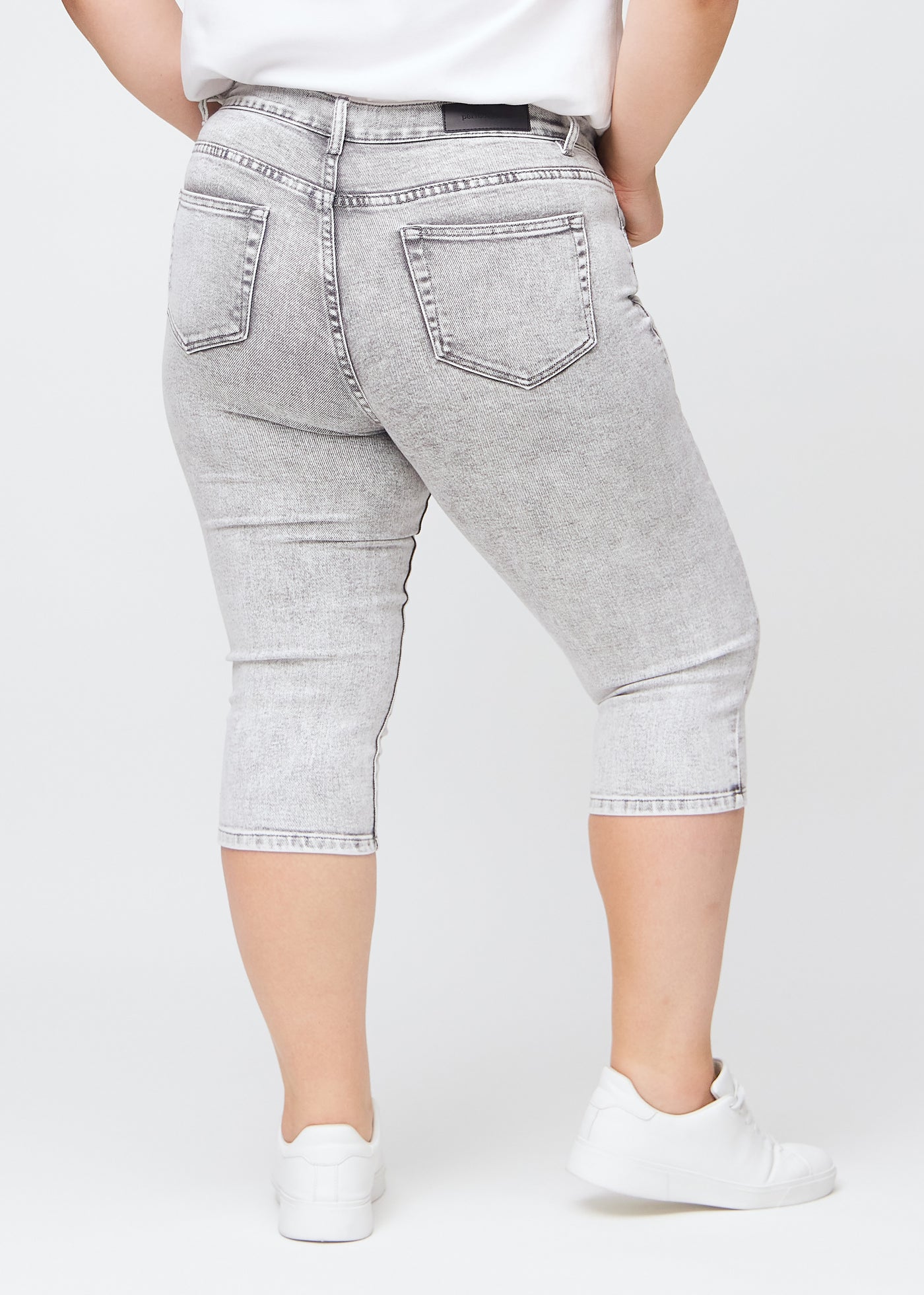 Lysegrå denim skinny capris set bagfra på en plus-size model, så man kan se hele produktet.