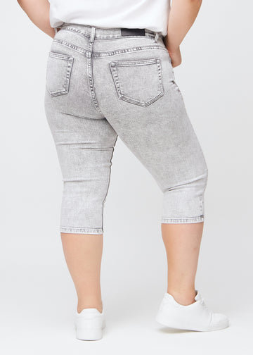 Lysegrå denim skinny capris set bagfra på en plus-size model, så man kan se hele produktet.