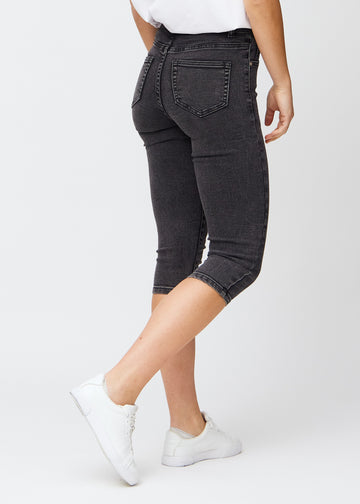 Mørkegrå denim skinny capris set bagfra, så man kan se hele produktet.