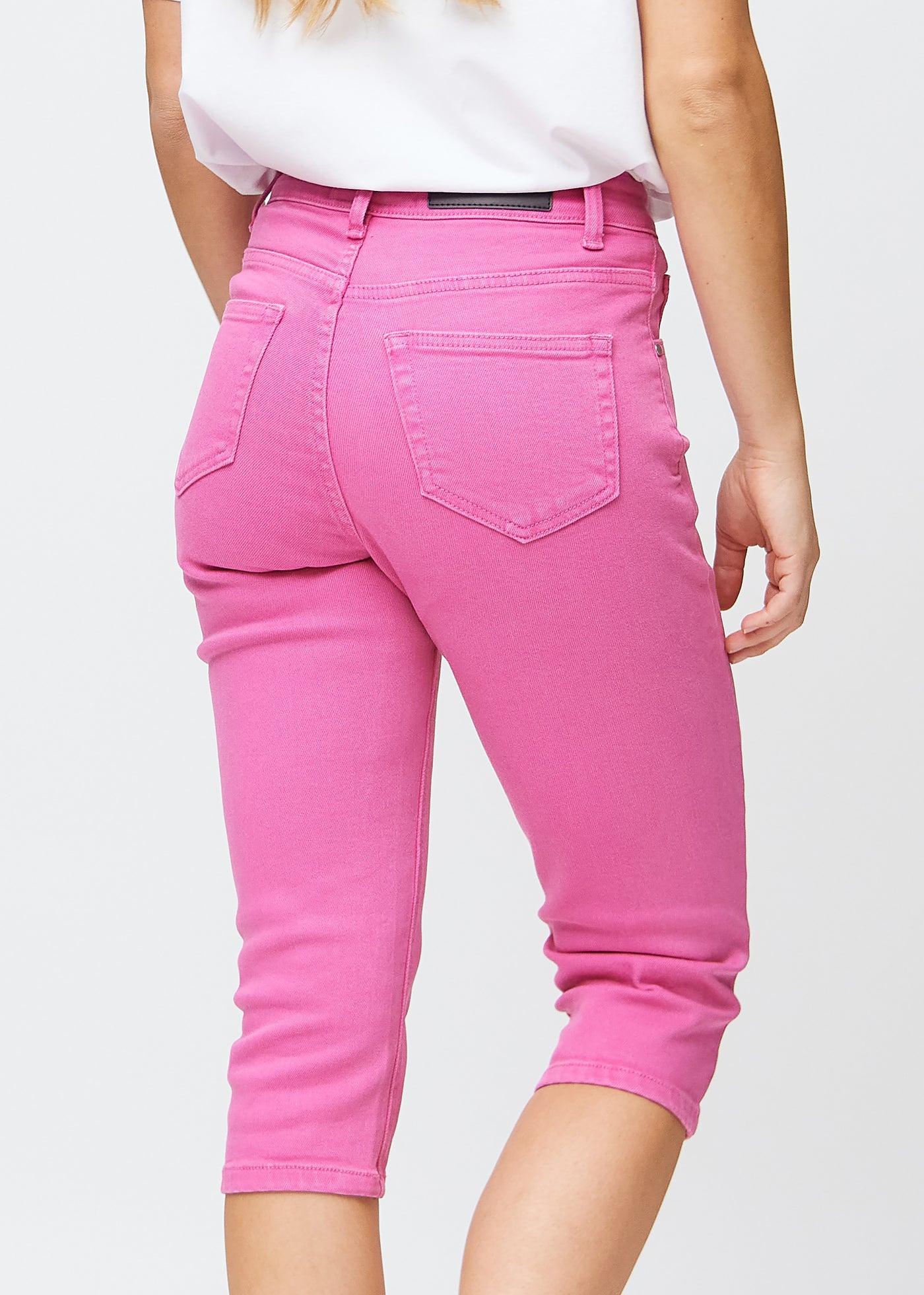 Tæt billede af de lyserøde slim capris bagfra, så man tydeligt kan se detaljer og lommer.