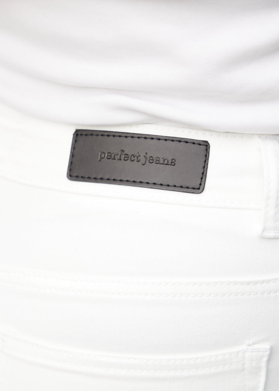 Nærbillede af hvidt jeansmateriale med Perfect Jeans læderpatch bagpå i taljen, på en plus-size model.