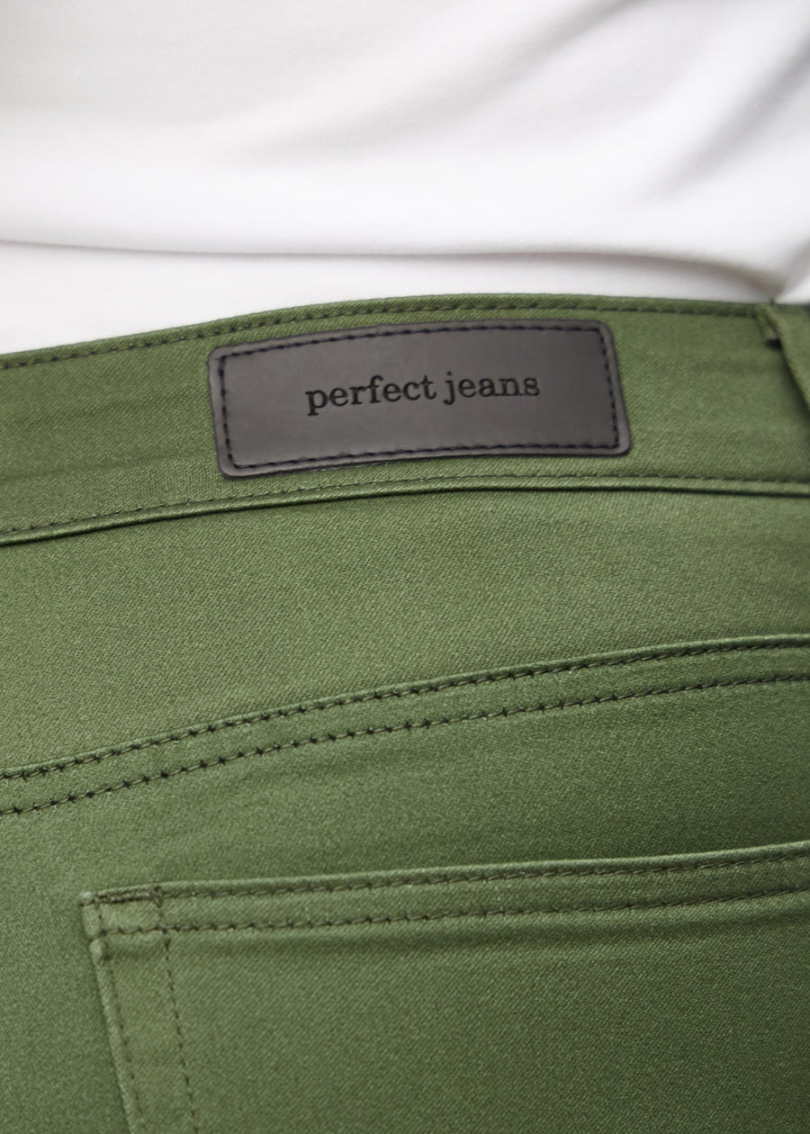 Nærbillede af grønt jeansmateriale med Perfect Jeans læderpatch bagpå i taljen, på en plus-size model.