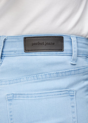 Nærbillede af lyseblåt jeansmateriale med Perfect Jeans læderpatch bagpå i taljen.