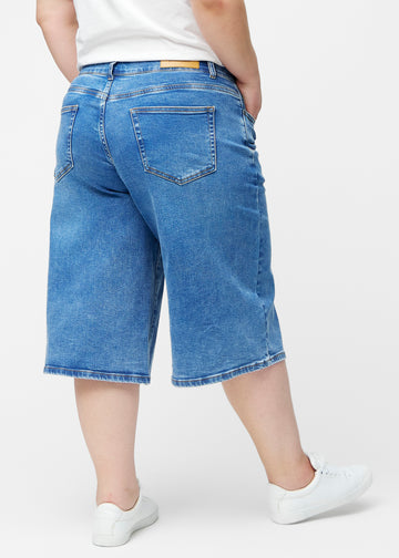 Løse, klassisk blå denim capris i farven Rivers set bagfra på plus-size model, så pasform og længde kan ses.