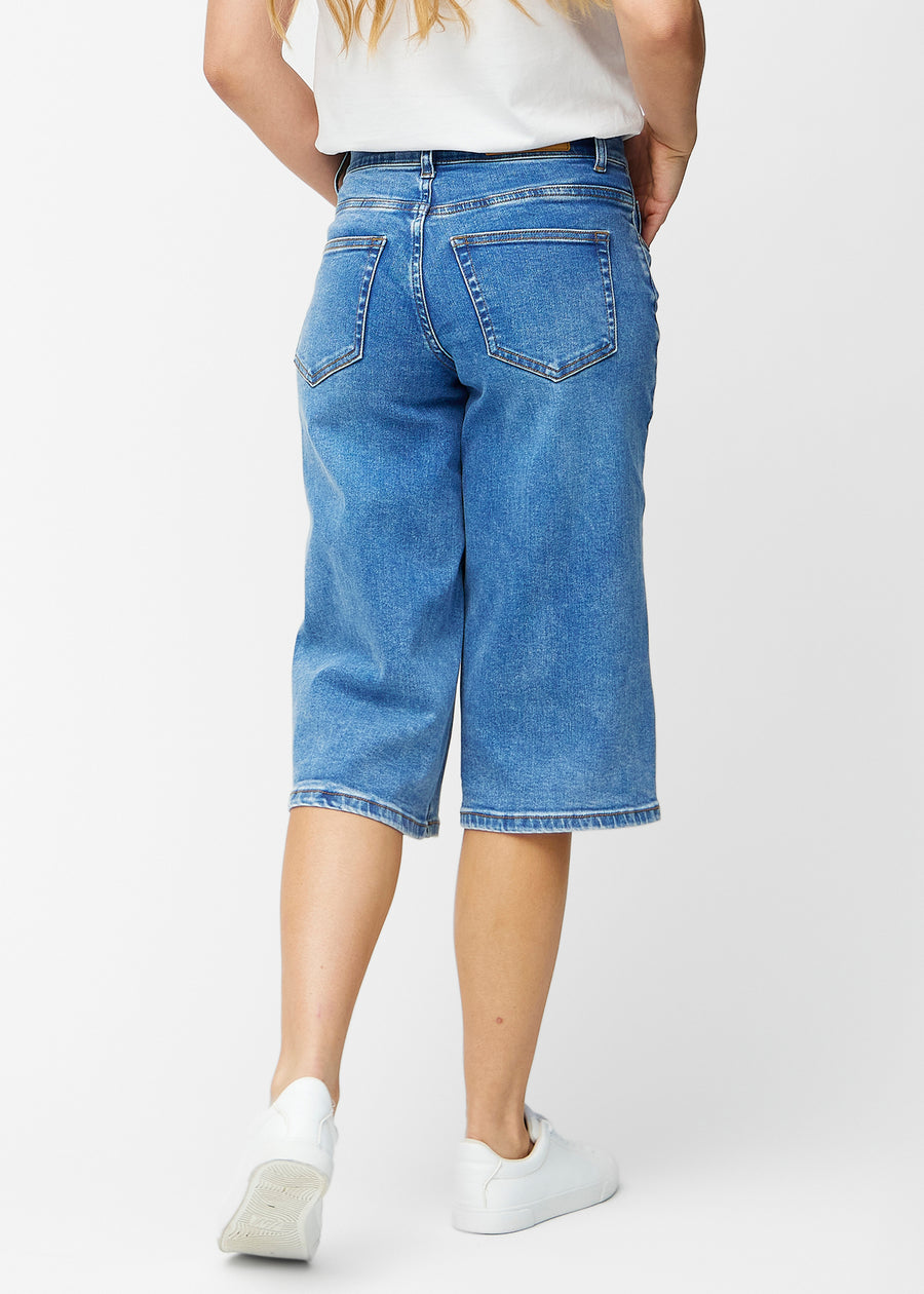 Løse, klassisk blå denim capris i farven Rivers set bagfra, så pasform og længde kan ses.