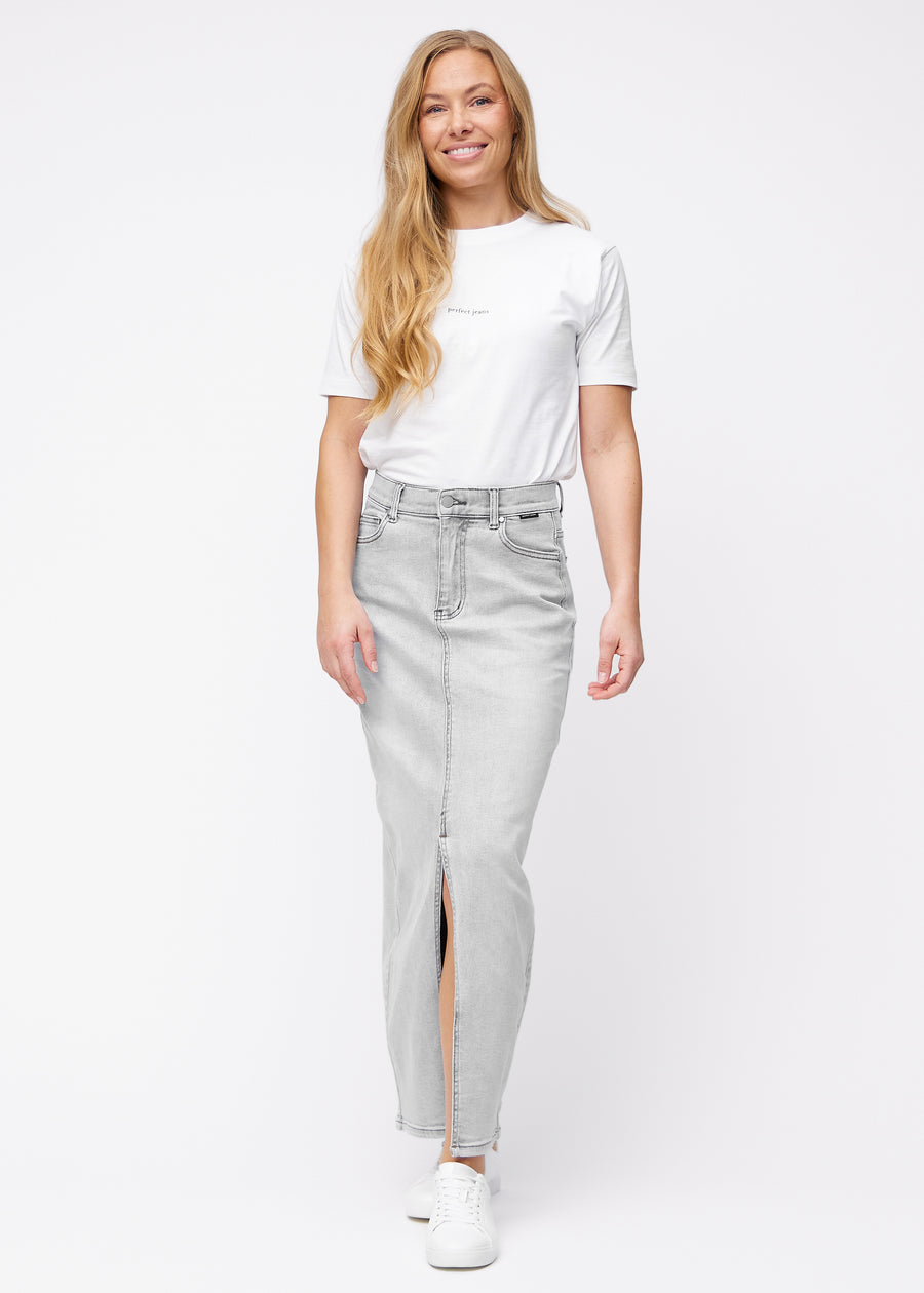 Fuldt billede af model i lang, lysegrå denimnederdel i farven Ashes med regulær pasform og slids foran.