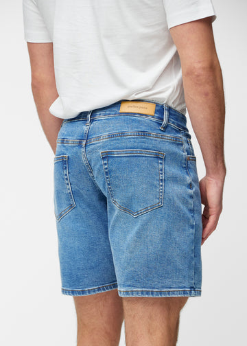 Blue denim shorts for men in the colour Rivers seen from the back close up to show fit and details.