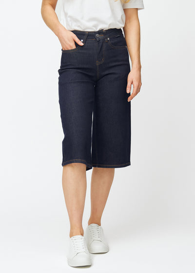 Deep dark blue denim capris for women in the colour Midnights with a loose fit, sitting at the hips and falling loosely over the thighs and legs, seen from the front.