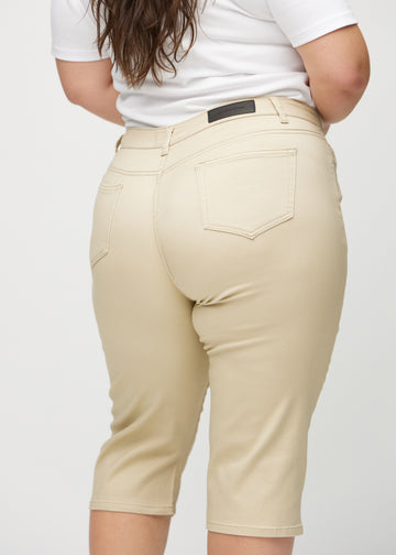Beige regular capris seen from the back close up on a plus-size model to show details.
