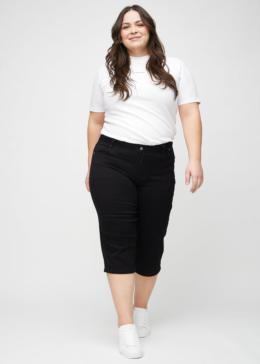 Full-length image of a plus-size model wearing black regular capris.