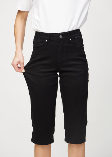 The model stretches the capris at the thigh to show the stretch.