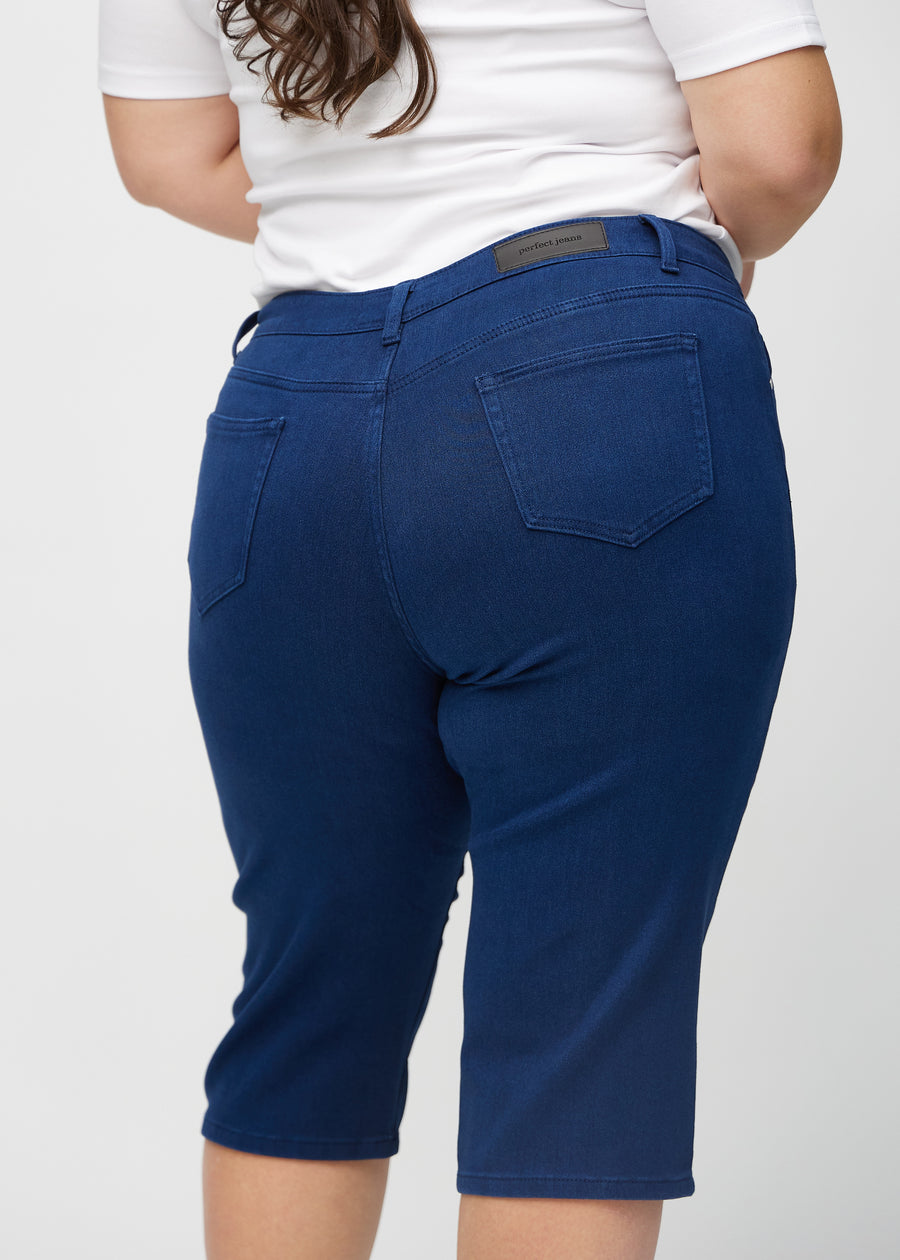 Dark blue regular capris seen from the back up close on a plus-size model to show details.