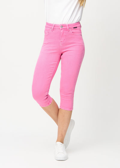 Skinny capris for women in pastel pink fabric, color Flamingos. Front view on a model, showing the close-fitting legs ending just below the knee.