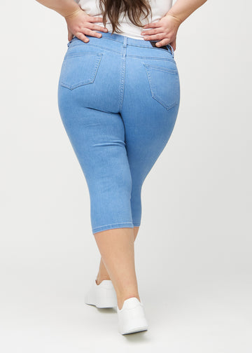 Skinny capris for women in blue fabric, color Geraniums. Back view on a plus-size model, showing the fit and back pockets.