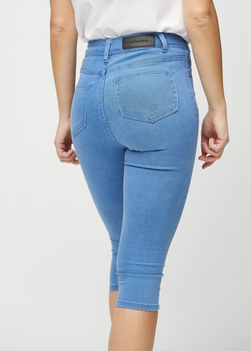 Skinny capris for women in blue fabric, color Geraniums. Close-up from behind on a model, highlighting pockets and stitching.