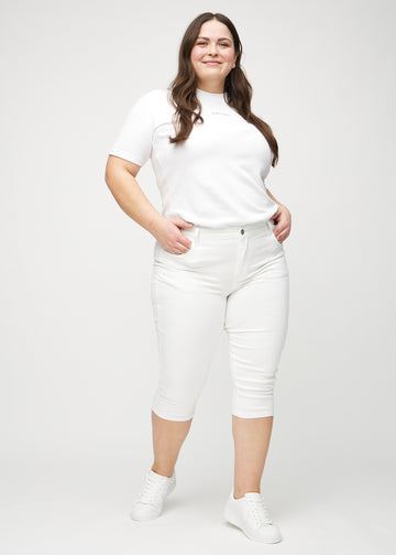 Skinny capris for women in white fabric, color Marguerites. Full-length view of a plus-size model wearing the capris.
