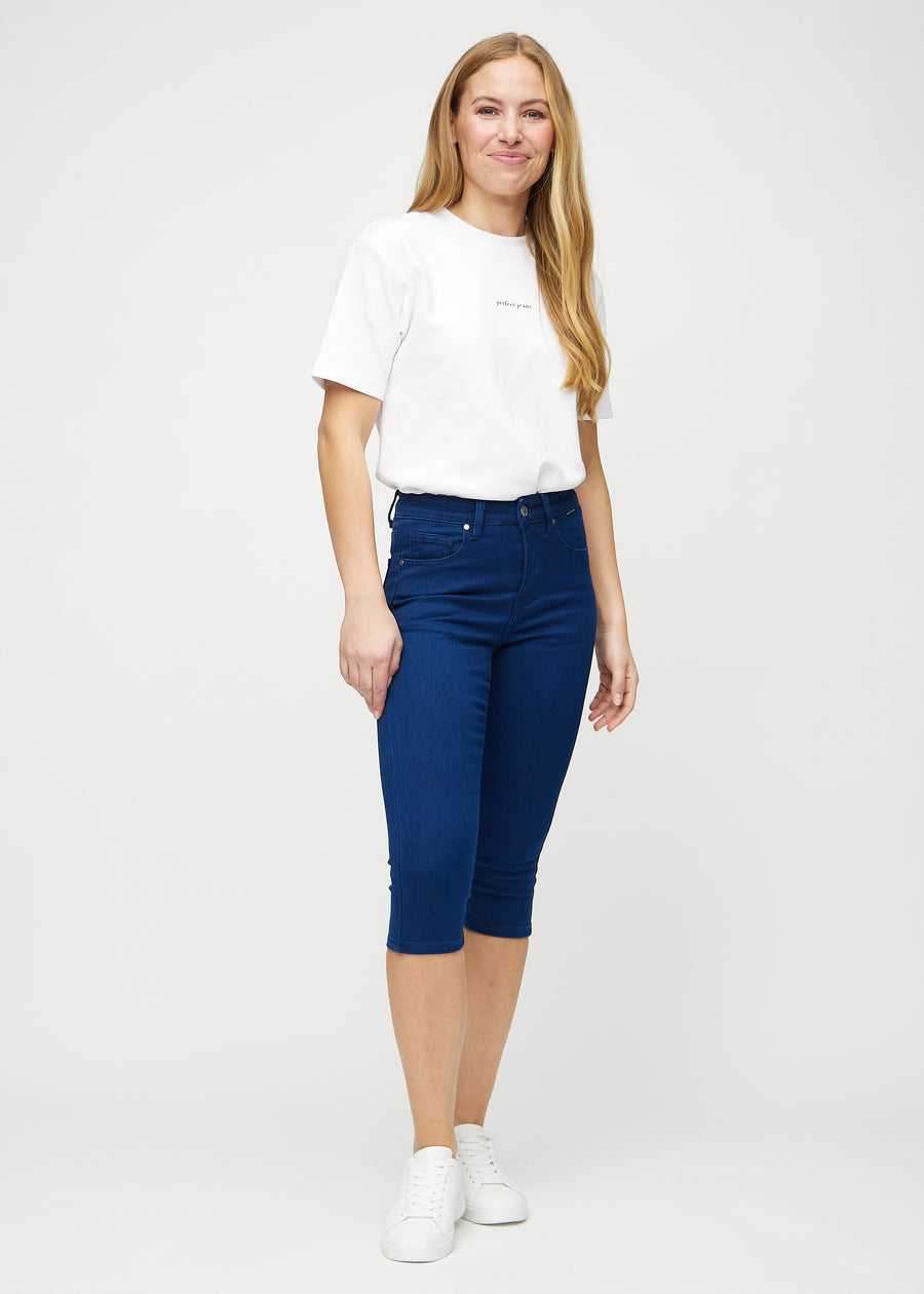 Full image of model in dark blue skinny capris.