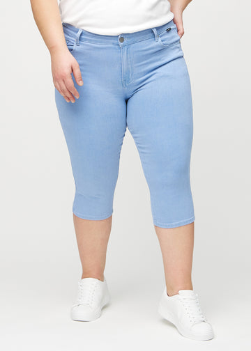 Skinny capris for women in light blue fabric, color Skies. Front view on a plus-size model, showing the close-fitting legs ending just below the knee.