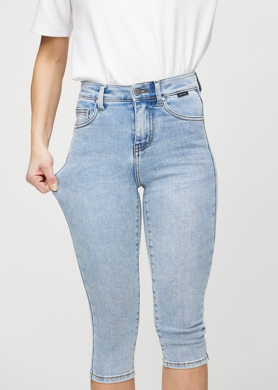 The model stretches the capris at the thigh to show the stretch.