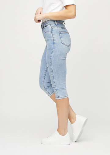 Light denim skinny capris viewed from the side on a model.