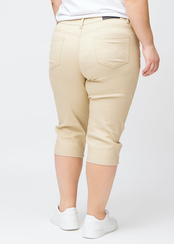  Beige slim capris seen from the back on a plus-size model, clear image of the full product and pockets.