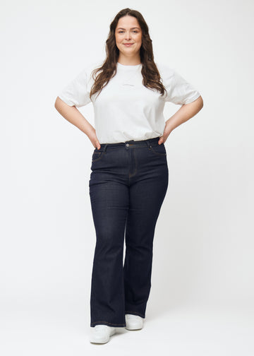 Full image of a plus-size model in deep dark blue denim jeans for women in the color Midnights with a bootcut fit.