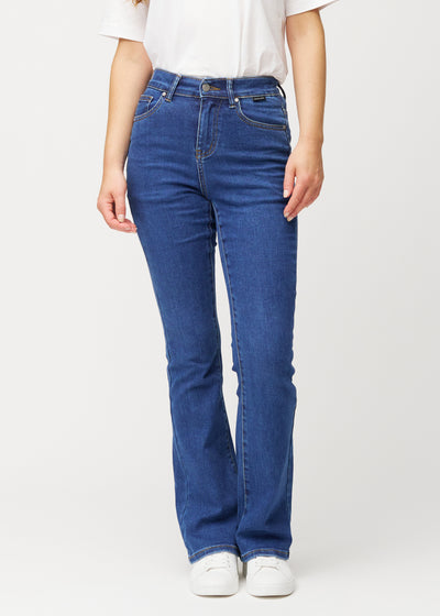 Dark blue mid-rise bootcut jeans in Oceans. Front view on a model, fitted through the hips and thighs with a gentle flare at the hem.