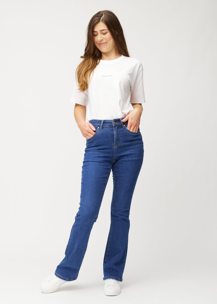 Dark blue mid-rise bootcut jeans in Oceans. Full-length view of a model wearing the jeans.