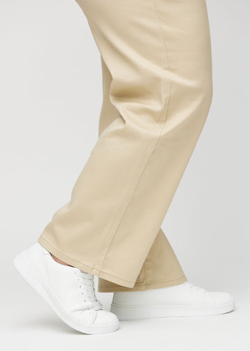 Loose jeans for women in beige, color Gazelles. Close-up at the ankles on a plus-size model, showing the wide leg openings.
