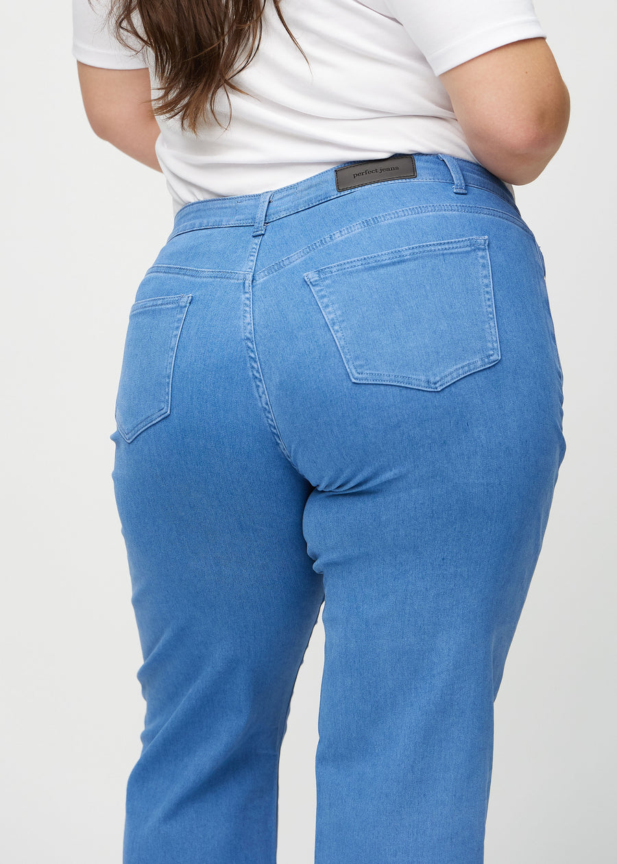 Blue loose jeans seen from the back close up on a plus-size model to show details.