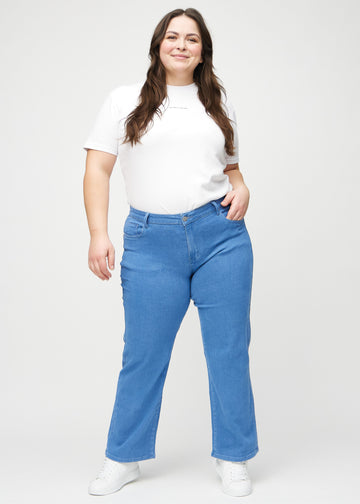 Full image of a plus-size model in blue loose jeans.