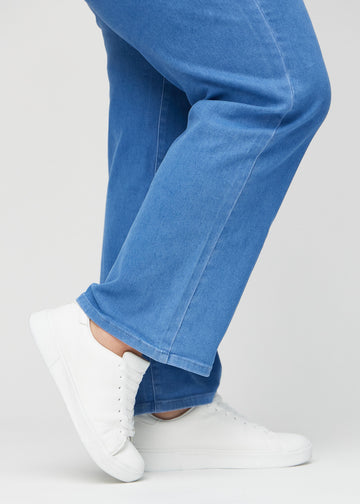 The ankles of a plus-size model, so you can see how loose the jeans fit.