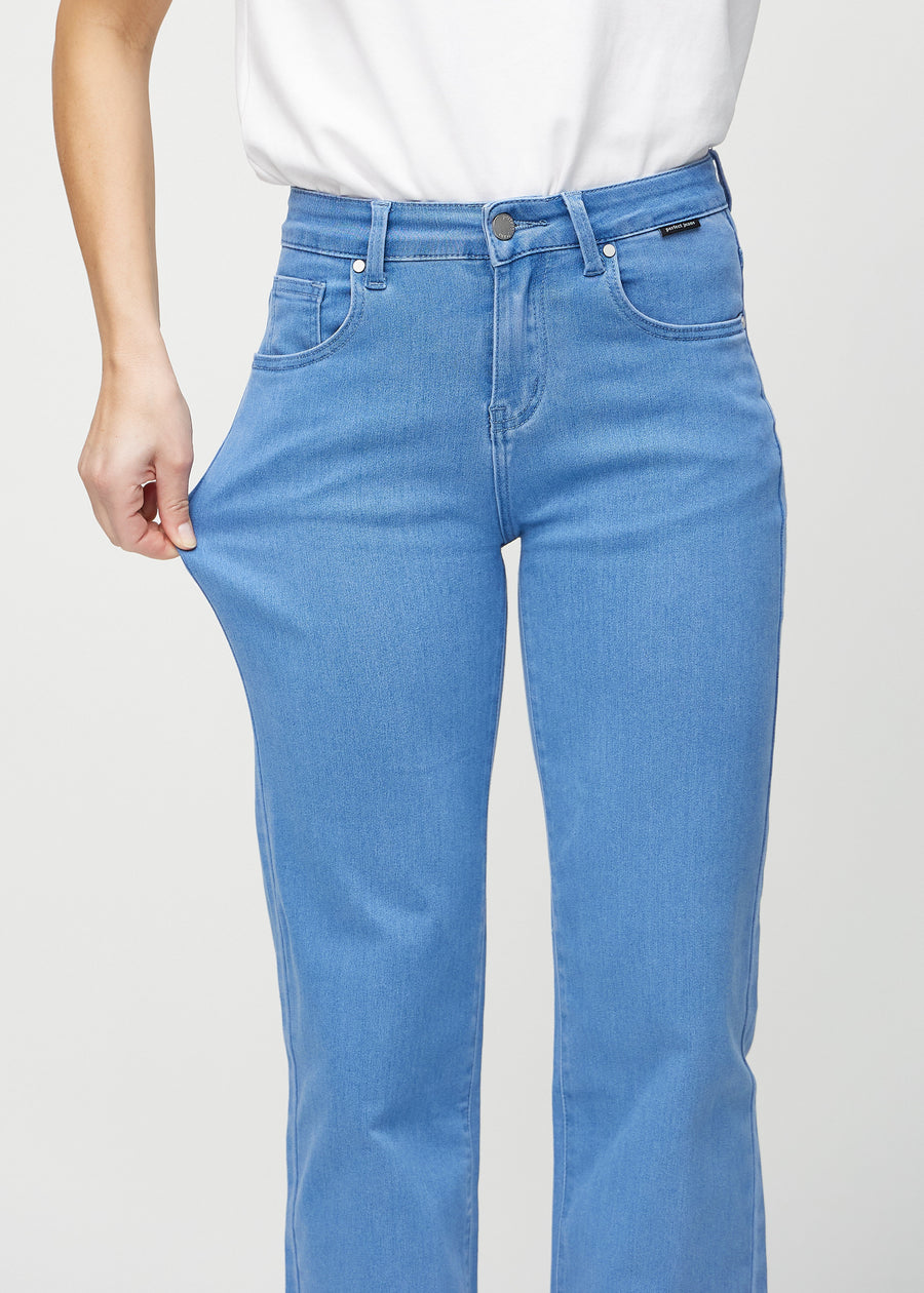 The model stretches the jeans at the thigh to show the stretch.
