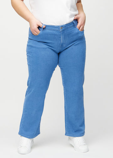 Blue loose jeans, model name Geraniums, which is loose-fitting with plenty of width in the legs on a plus-size model, seen from the front.