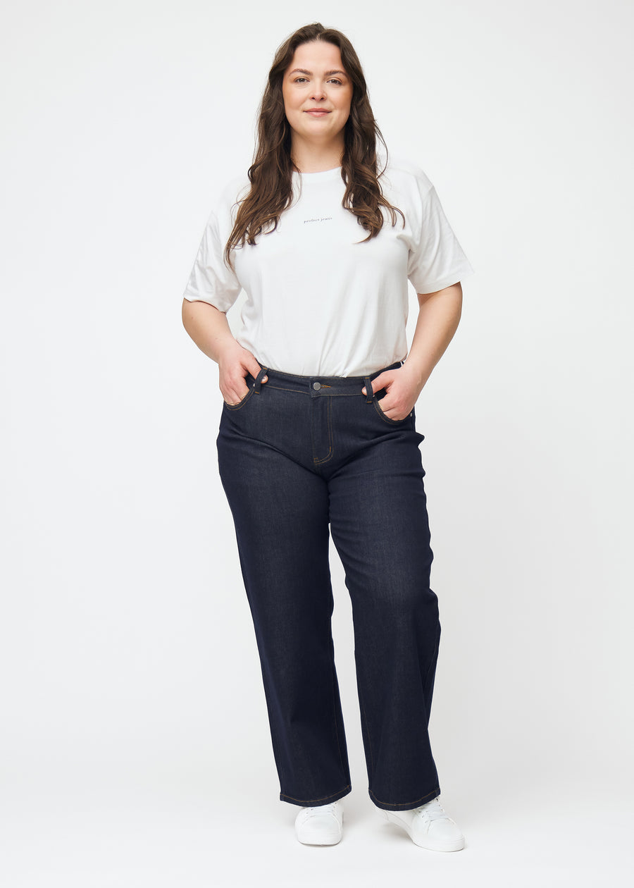 Full image of a plus-size model in deep dark blue denim jeans for women in the color Midnights with a loose fit.