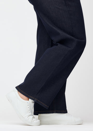 Deep dark blue denim jeans for women in the color Midnights with a loose fit, shown close up at the ankles on a plus-size model to show the wide hem.