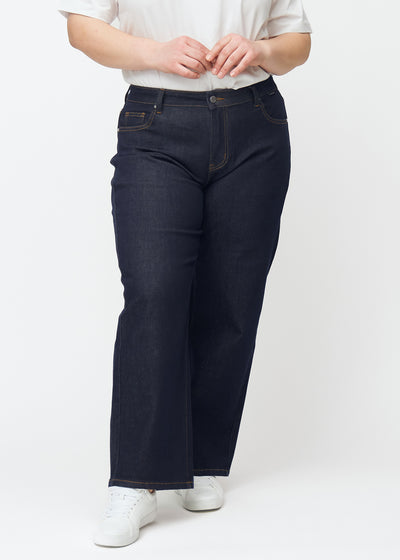 Deep dark blue denim jeans for women in the color Midnights with a loose fit, shown from the front on a plus-size model.