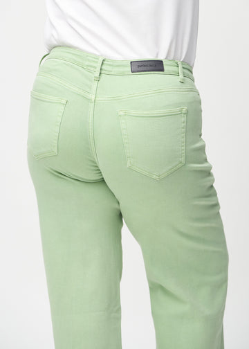 Light green loose jeans seen from the back close up on a plus-size model to show details.
