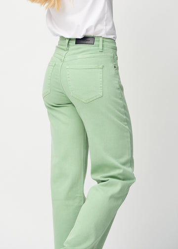 Light green loose jeans seen from the back close up to show details.
