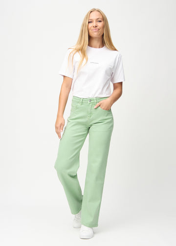 Full image of model in light green loose jeans.
