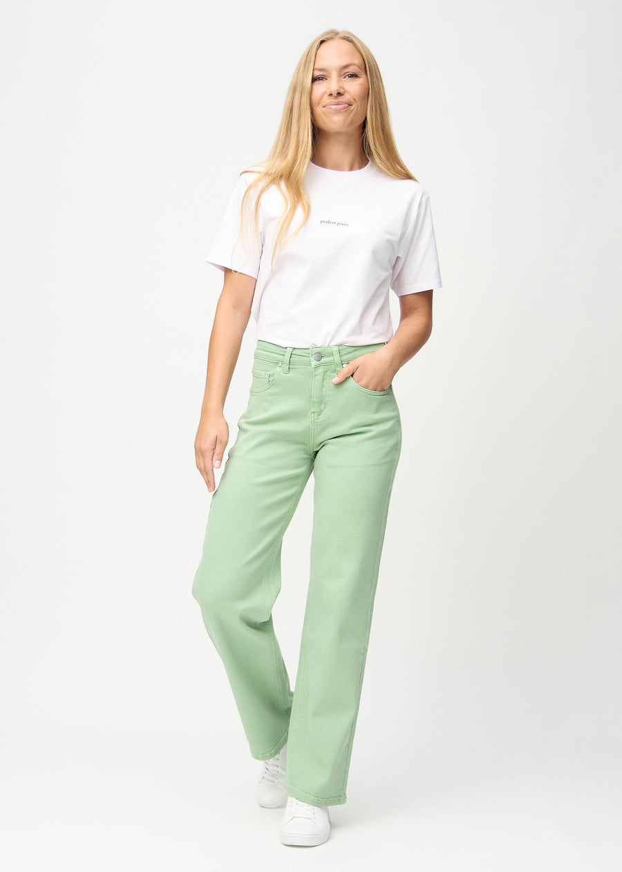 Full image of model in light green loose jeans.
