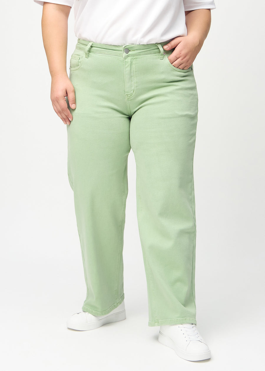 Light green loose jeans, model name Mints, which are loose-fitting with plenty of width in the legs on a plus-size model, seen from the front.

