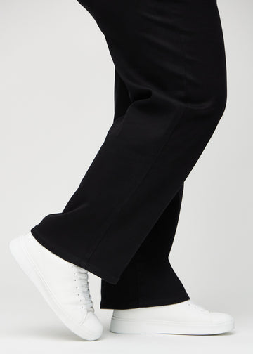 The ankles of a plus-size model, so you can see how loosely the jeans fit in a Loose fit.