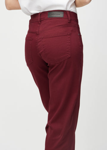 Loose jeans for women in dark red, color Santas. Close-up from behind on a model, showing the fit and details.