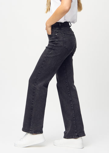 Loose jeans for women in dark grey, color Shadows. Side view on a model, showing the loose fit.