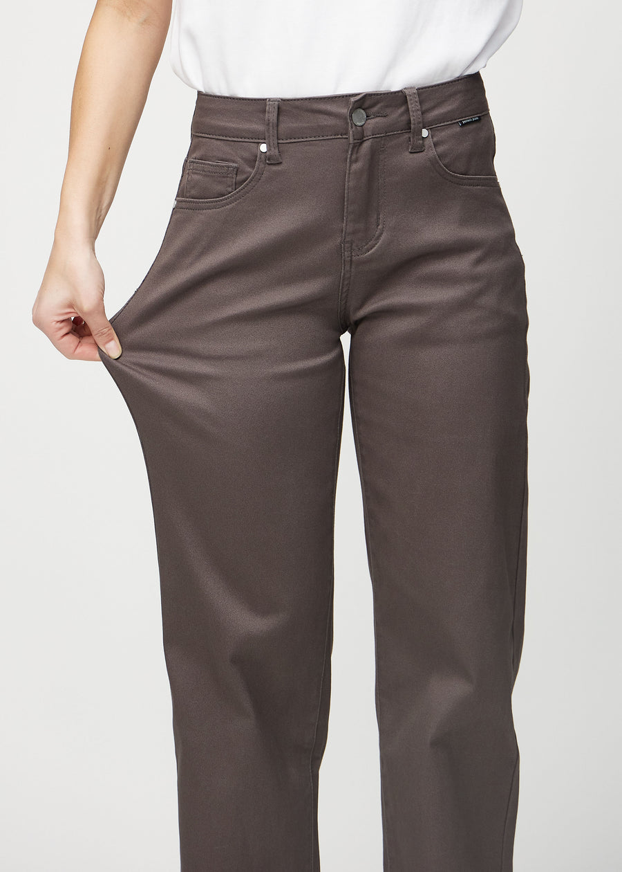 The model stretches the jeans at the thigh to show the stretch.