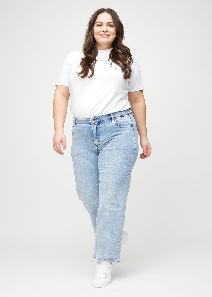 Full image of a plus-size model in light denim loose jeans.